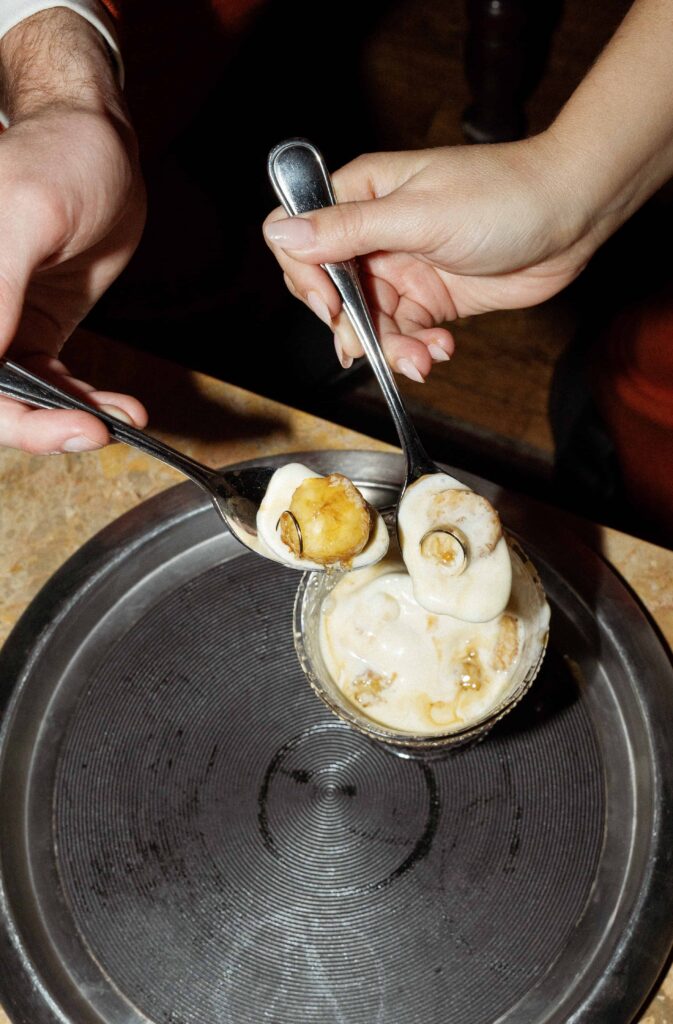 The bride and grooms rings are in a banana foster with spoon.