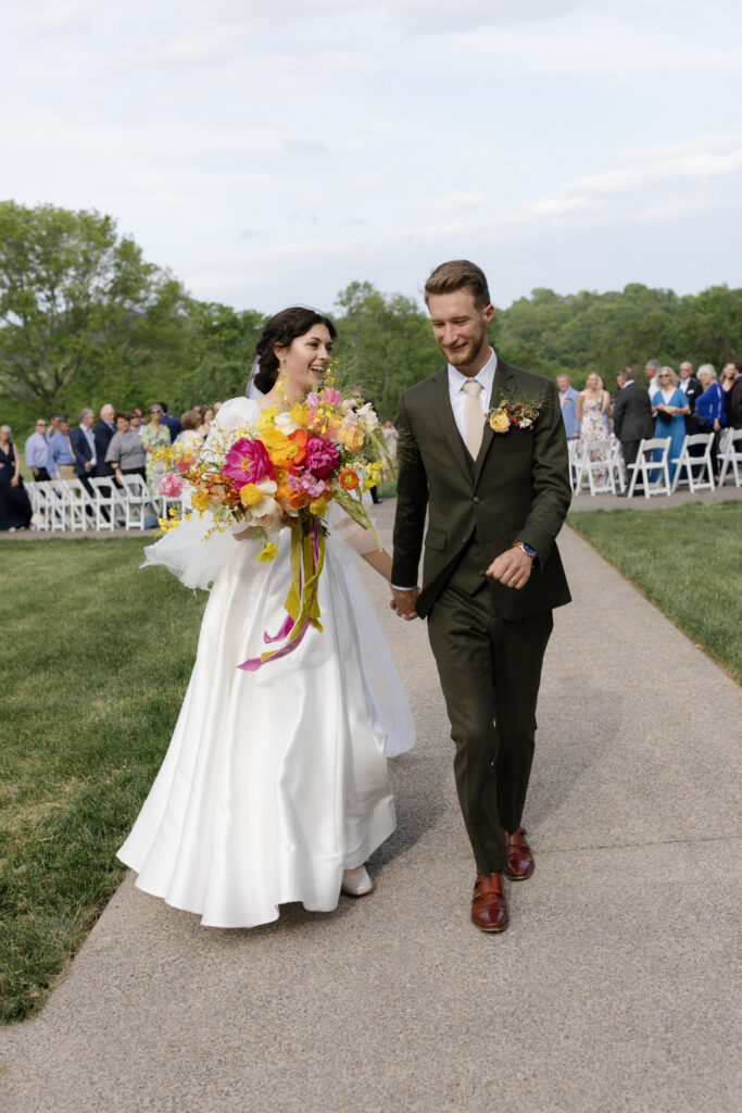 The bride and groom walking down the aisle after saying I do.